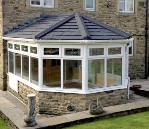 Conservatory with brick base, upvc windows and solid tiled roof