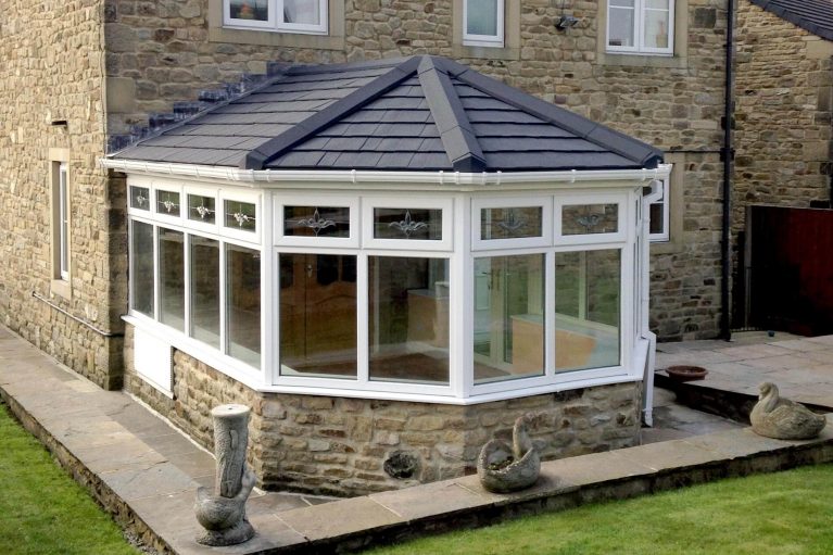 Conservatory with brick base, upvc windows and solid tiled roof
