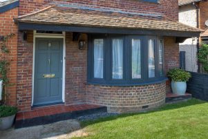 An installation of a bow style window in grey uPVC